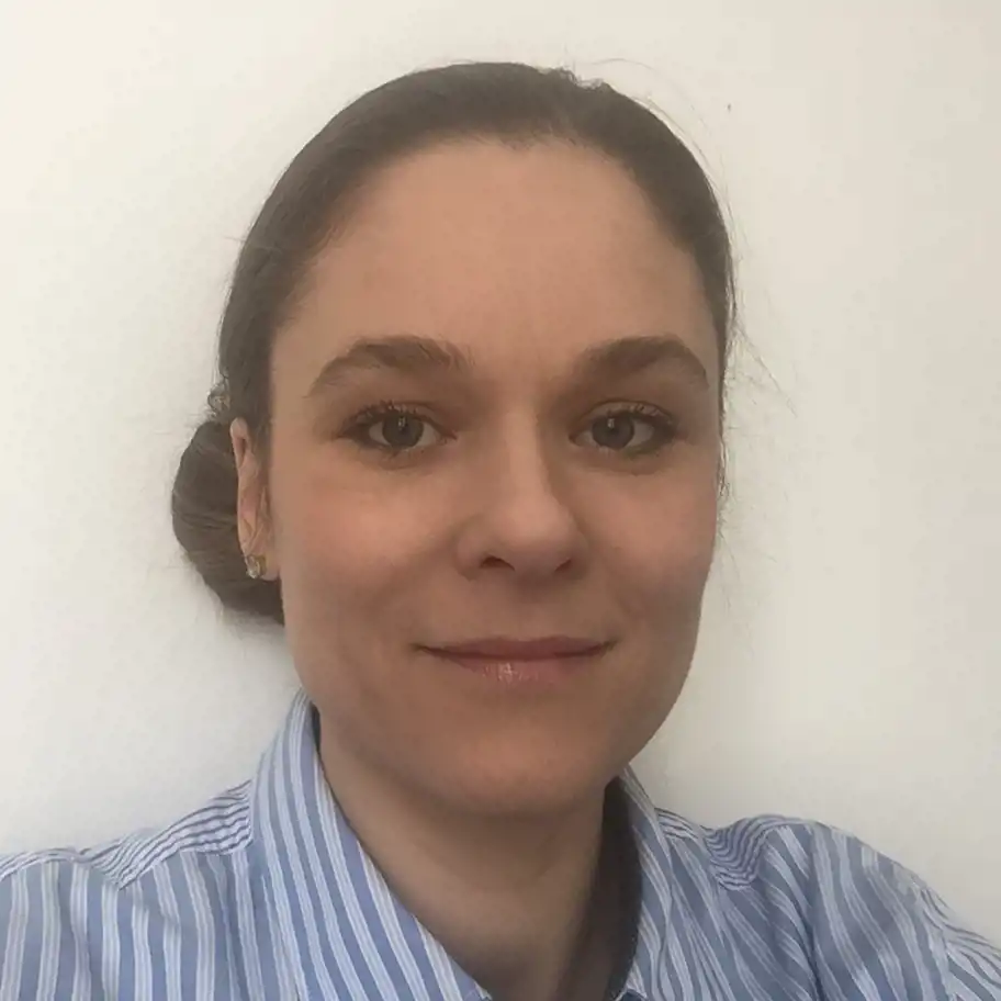 Rebecca Engelbert, vd och verksamhetschef på Medisera Health, ler lätt mot kameran. Hon har uppsatt hår och bär en blå- och vitrandig skjorta, med vit bakgrund.